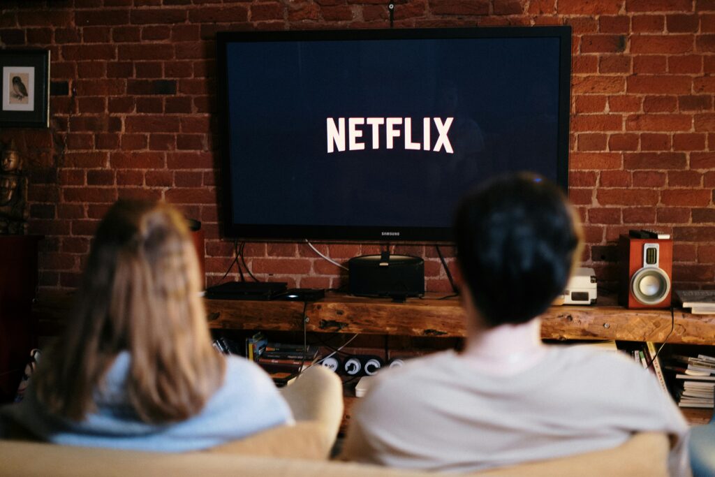 A couple relaxing and watching Netflix in a cozy living room setting.